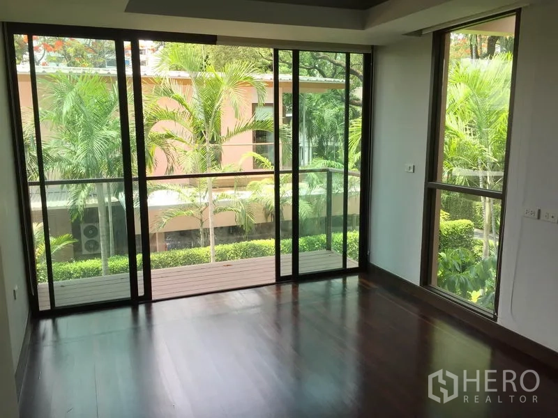 独立式住宅 出租在Sathon, Bangkok - 卧室配落地窗与阳台，俯瞰热带绿景