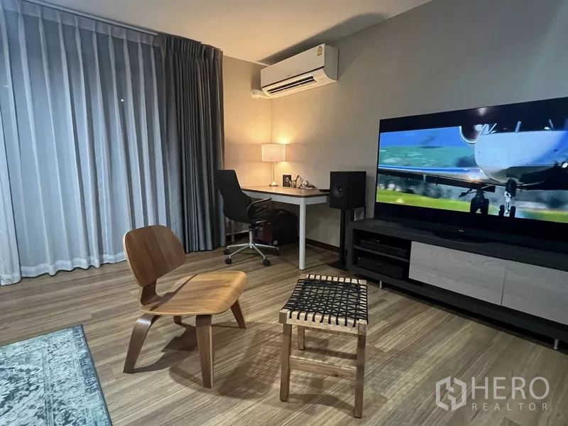 Townhouse for rent or sale in Suan Luang, Bangkok - Quiet study and TV corner with desk, large screen and wood flooring.