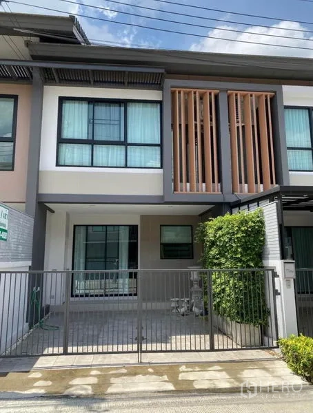 联排别墅 出租在Prawet, Bangkok - 曼谷Prawet区两层联排别墅外观，带围栏车位与木质格栅立面。