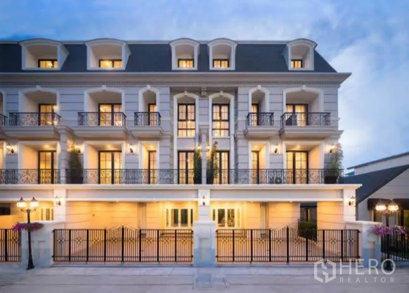 Townhouse for rent in Yan Nawa, Bangkok - Four-storey European-style townhouse facade with wrought-iron balconies and gated parking at dusk.