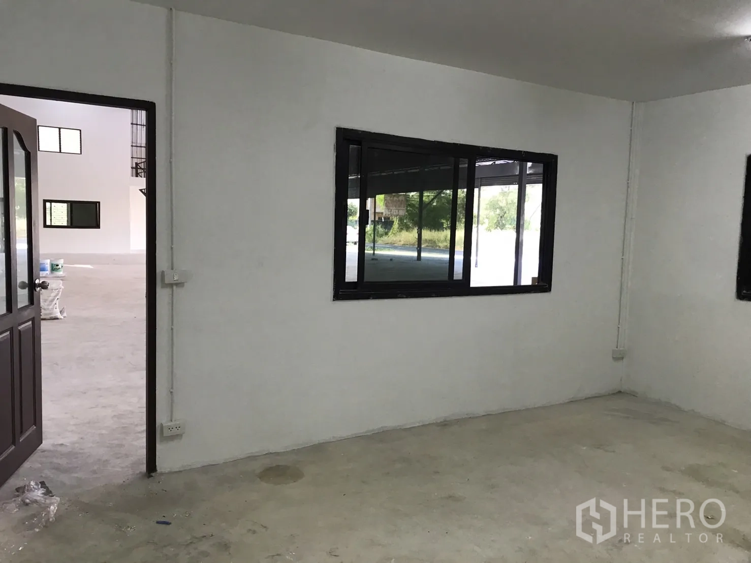 Warehouse for rent in Lam Luk Ka, Pathum Thani - Ground-floor office space with windows opening to the warehouse area.