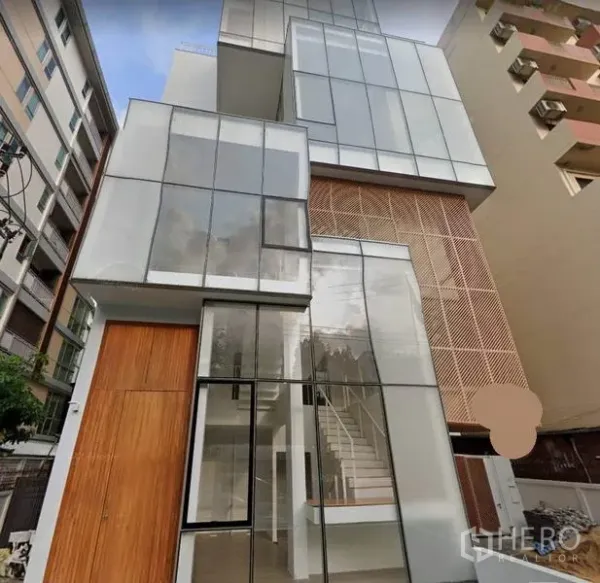 Home Office for rent in Phaya Thai, Bangkok - Modern multi-level home office exterior with floor-to-ceiling glass panels, wood accents and a visible staircase in Ari, Phaya Thai, Bangkok.
