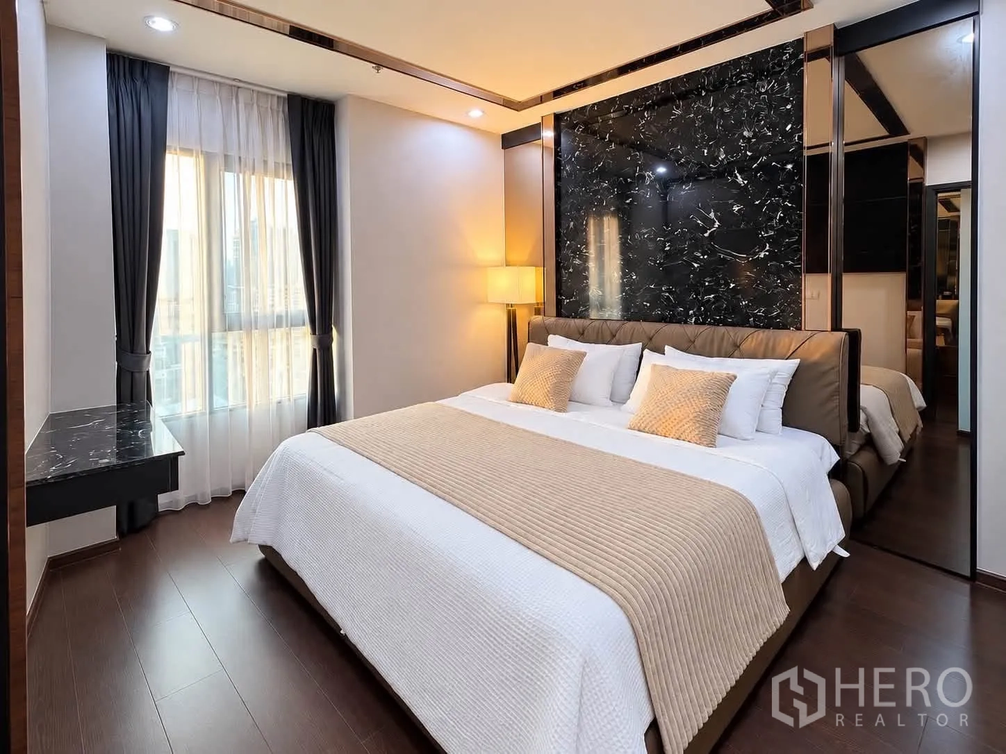 Condominium for rent in Watthana, Bangkok - Primary bedroom with king bed, marble accent wall, and soft lighting.