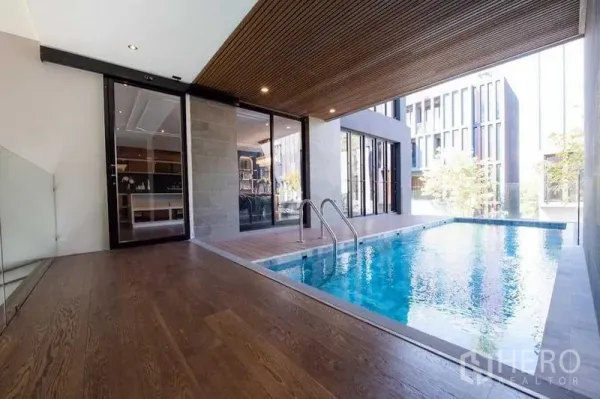 บ้าน ขายในPrawet, Bangkok - สระว่ายน้ำส่วนตัวแบบกึ่งในร่ม เพดานไม้ และประตูกระจกเชื่อมพื้นที่ภายใน