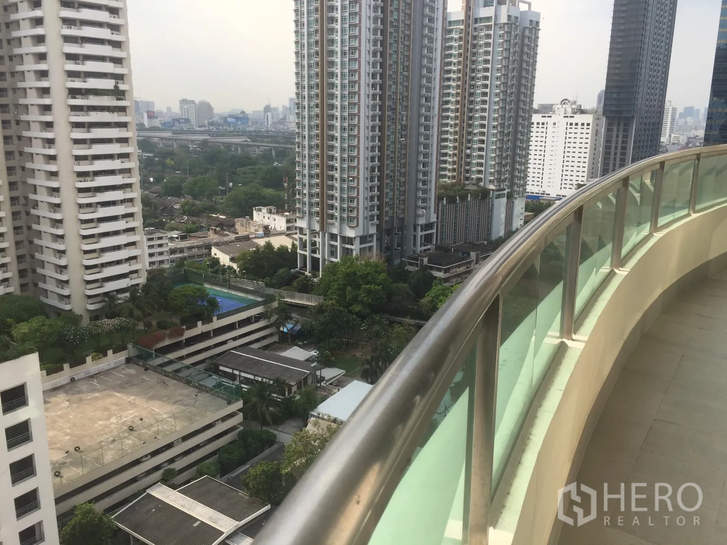 公寓 for 在Watthana, Bangkok - 弧形玻璃栏杆阳台，俯瞰曼谷天际线与高楼景观。