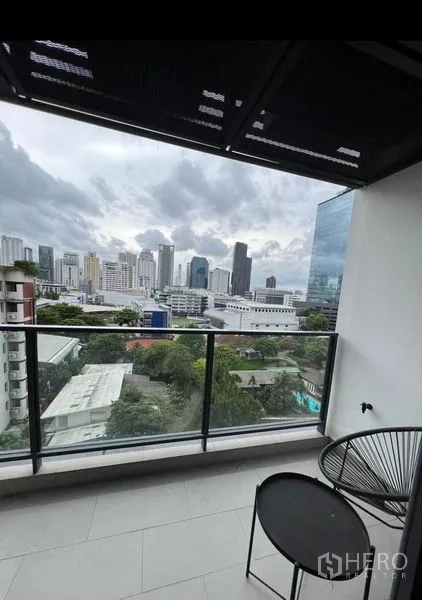 公寓 出租在Watthana, Bangkok - 私家阳台，玻璃护栏、户外小桌椅与城市景观