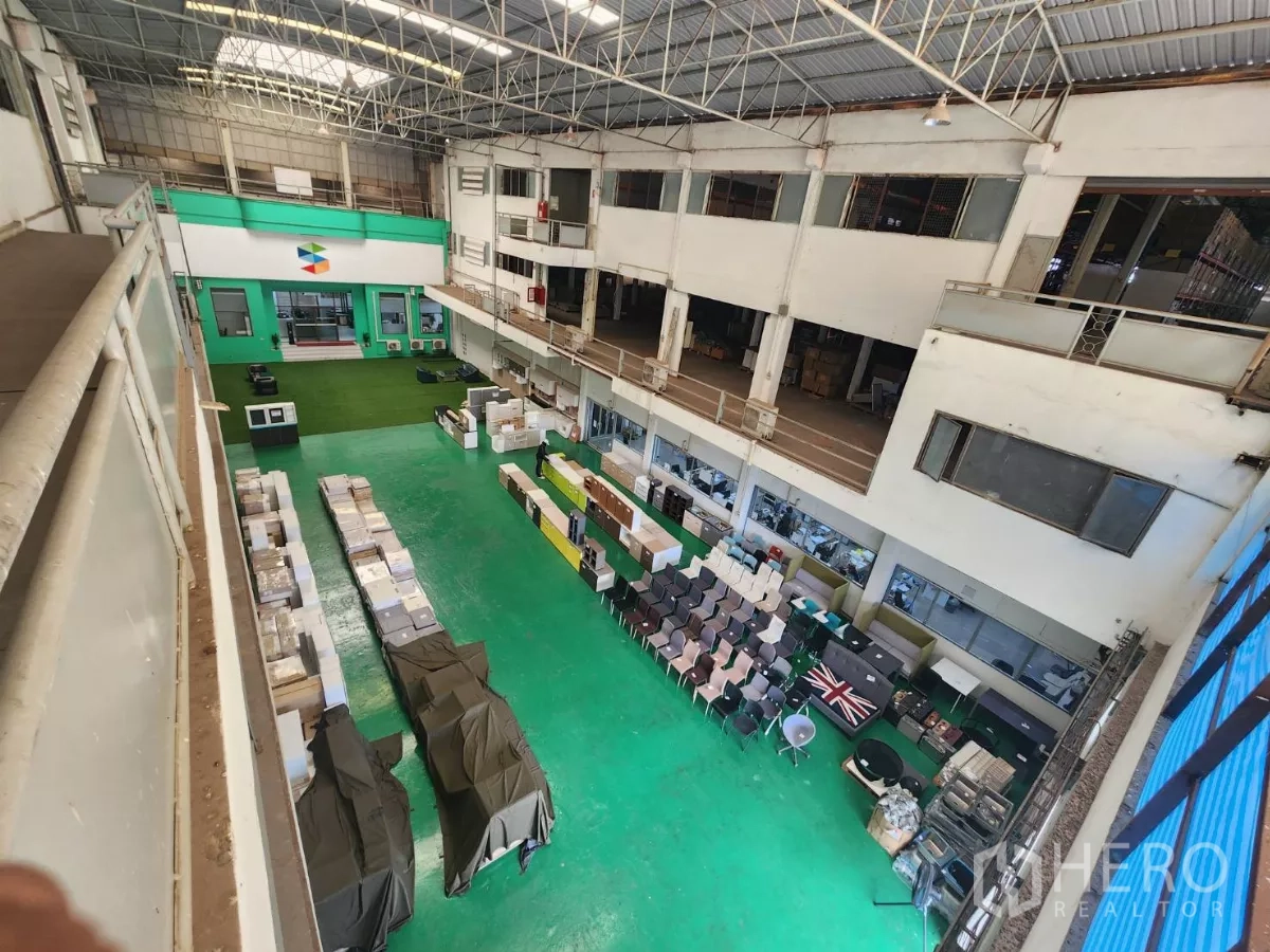 Factory for rent in Mueang Samut Sakhon, Samut Sakhon - Elevated view of the green‑floor hall showing mezzanine walkways and storage lines.