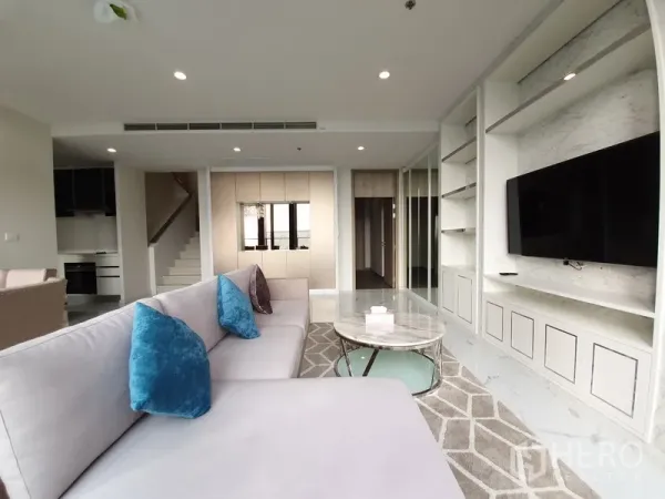คอนโด ให้เช่าในPathum Wan, Bangkok - ห้องนั่งเล่นร่วมสมัย โซฟาตัวใหญ่ ตู้บิลท์อินและผนังทีวี