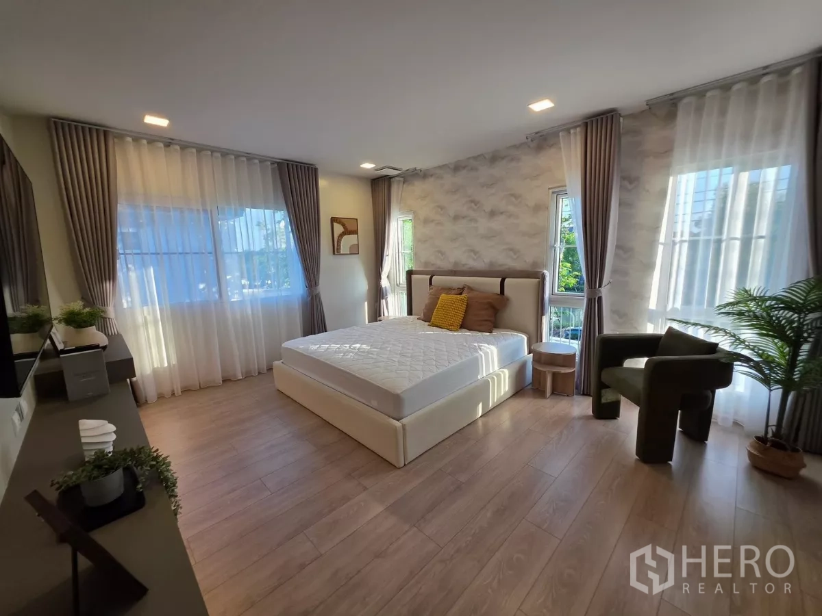 Detached House for rent in Bang Phli, Samut Prakan - Sunlit master bedroom with large bed, wood floors and multiple windows.