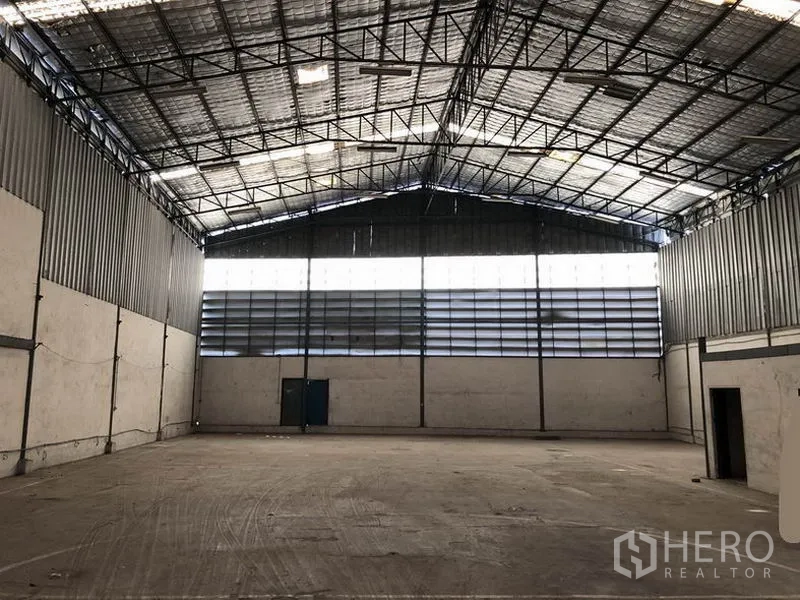Warehouse for rent in Suan Luang, Bangkok - Clear-span warehouse hall with ventilated side panels and skylights providing natural light.