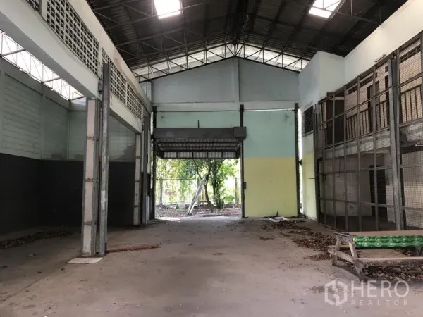 Warehouse for rent or sale in Lam Luk Ka, Pathum Thani - High-clearance warehouse interior with roller shutter door and natural light.