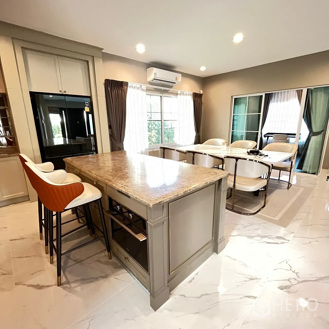 Detached House for rent or sale in Bang Khen, Bangkok - Modern kitchen with large marble island and two bar stools.