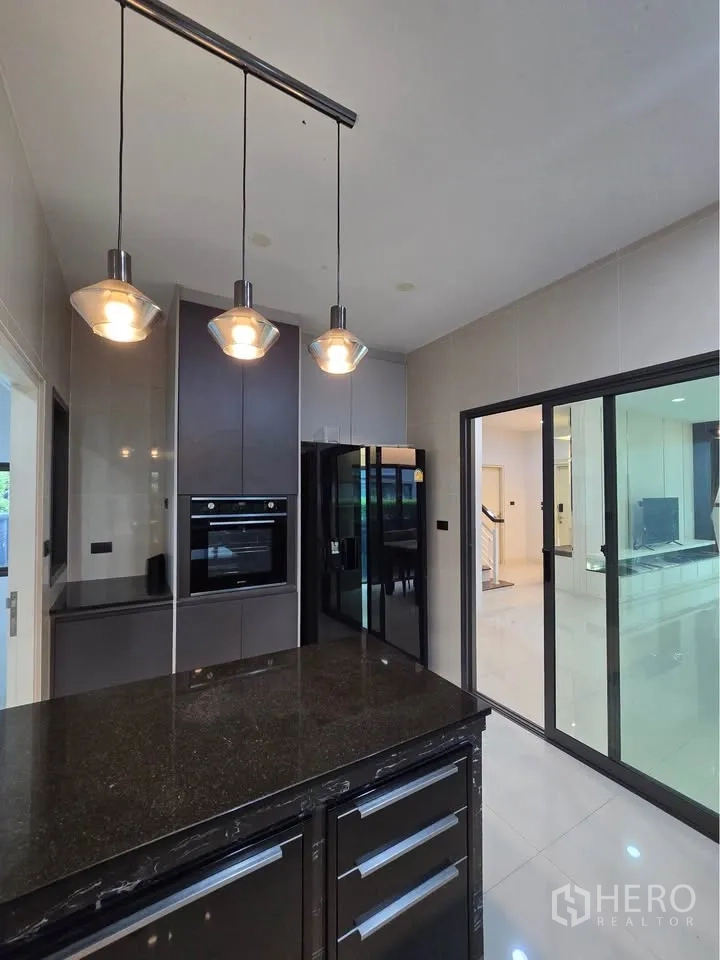 Detached House for rent in Bang Kapi, Bangkok - Modern kitchen island with pendant lights and built-in oven.