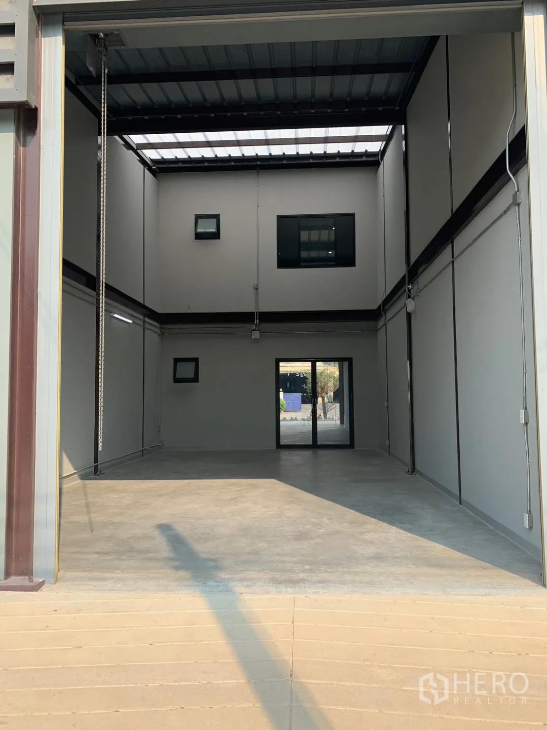 Warehouse for rent in Bang Phli, Samut Prakan - Front loading bay with raised roller shutter and entry ramp.