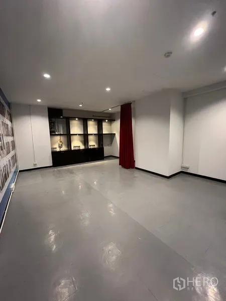 Retail Space for rent in Watthana, Bangkok - Open‑plan retail interior with grey floors, spotlights, and built‑in illuminated display cabinets.