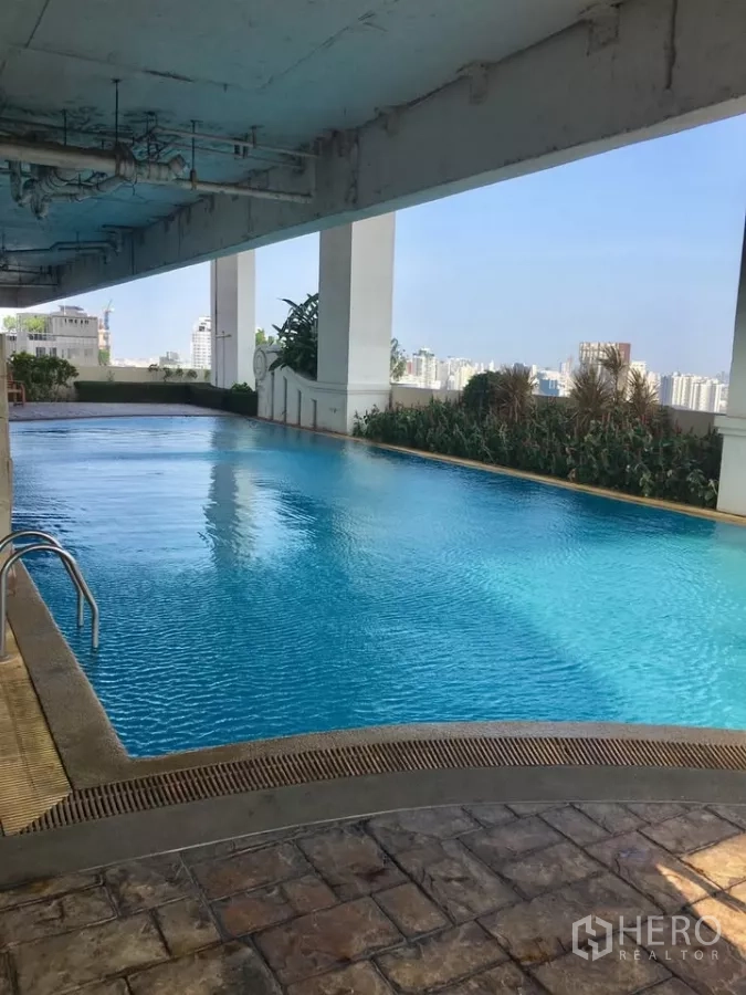 Condominium for rent in Khlong Toei, Bangkok - Covered lap pool on a high floor with city views along the edge.