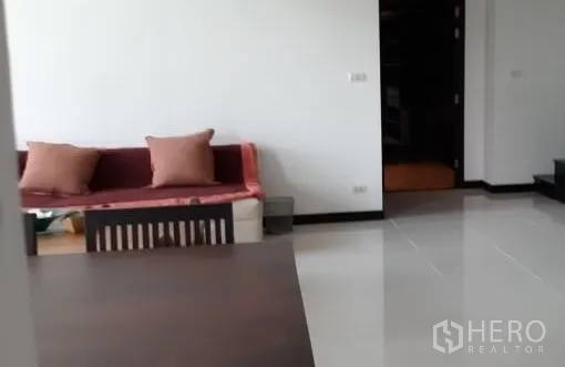 公寓 出租在Watthana, Bangkok - 开放式起居与用餐区的另一视角，亮面地砖与舒适沙发。