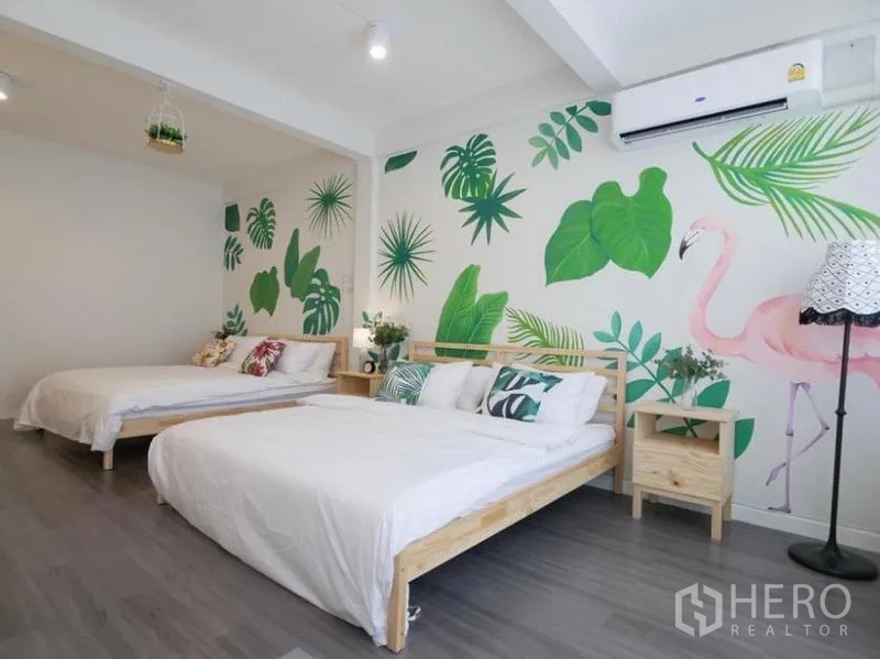 联排别墅 出租在Khlong Toei, Bangkok - 卧室另一角度，双人床两张，叶子与粉色火烈鸟墙绘，壁挂空调。