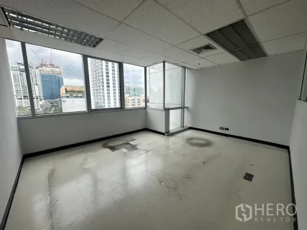 Office Space for rent - Private office room with corner windows and city views, grid ceiling and neutral flooring.