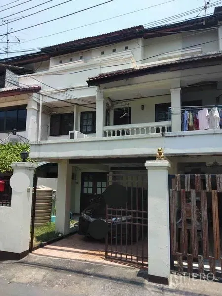 Townhouse for rent or sale in Wang Thonglang, Bangkok - Front facade of a two-storey townhouse with gated carport and upper balcony in Wang Thonglang.