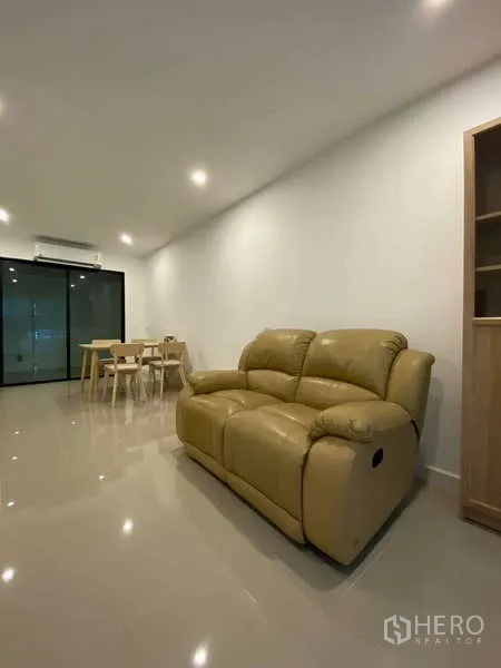 Townhouse for rent in Bang Kapi, Bangkok - Cozy seating area with beige leather sofa and recessed lighting.