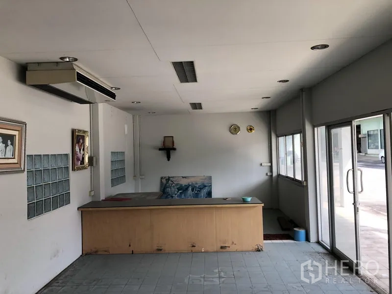 Warehouse for rent or sale in Lam Luk Ka, Pathum Thani - Reception office area with a built-in counter and glass sliding doors.