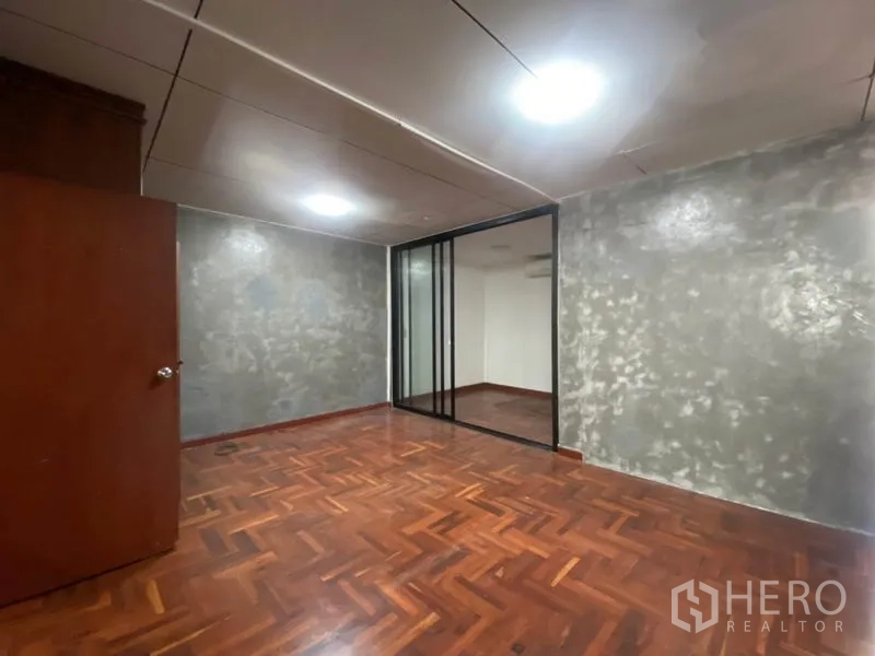 联排别墅 出租在Watthana, Bangkok - 房间带玻璃移门隔断与木地板，适合书房或加建卧室。