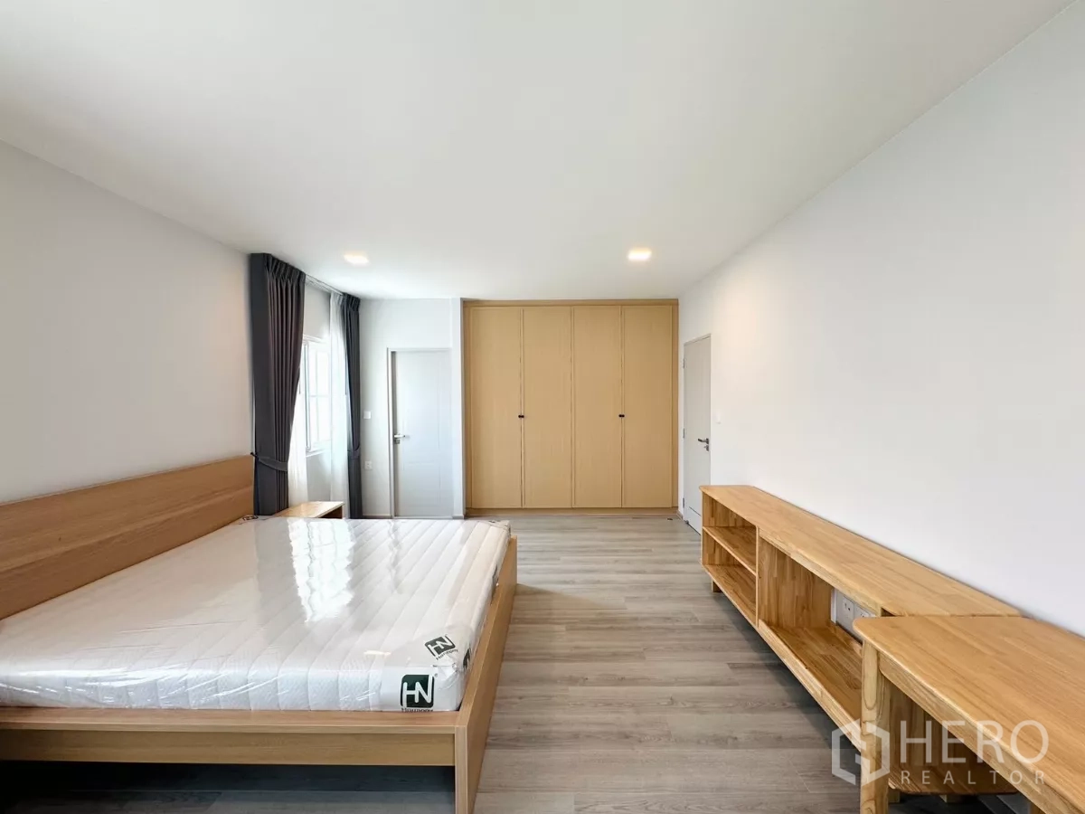 独立式住宅 出租在Bang Phli, Samut Prakan - 主卧对面视角，展示衣柜墙与套内卫浴门