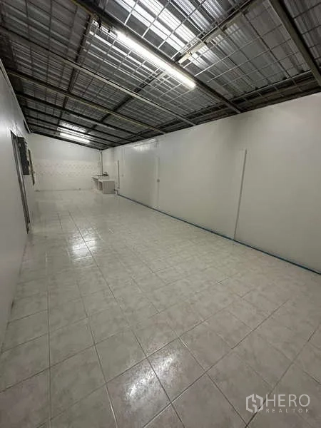 Home Office for rent in Din Daeng, Bangkok - Long open-plan area with white tiles, exposed ceiling and a small sink at the far end.
