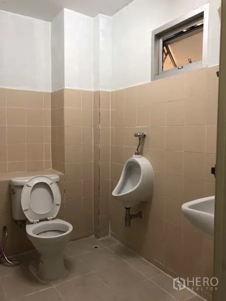 Warehouse for rent in Bang Phli, Samut Prakan - Clean tiled restroom with toilet, urinal and sink inside the warehouse.