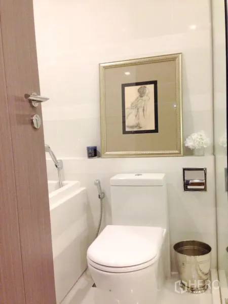 Condominium for rent in Khlong Toei, Bangkok - Second bathroom featuring a modern toilet, bathtub and framed artwork.