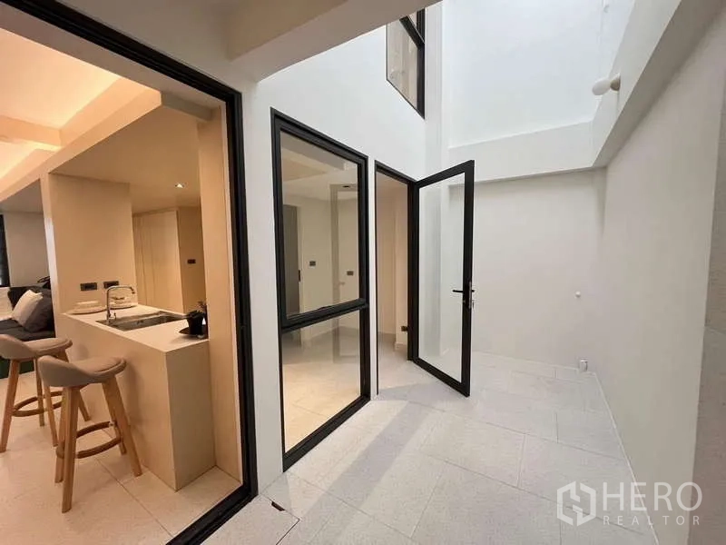 联排别墅 出售在Khlong Toei, Bangkok - 明亮的室内天井与采光井，配多扇玻璃门与高挑空间。