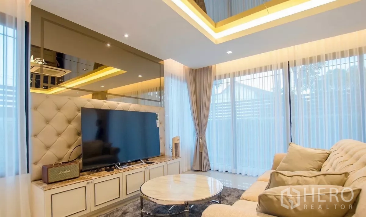 独立式住宅 出租在Bang Bon, Bangkok - 休闲角落，圆形大理石茶几、沙发与全景窗户。
