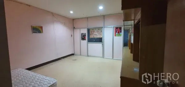 Warehouse for rent in Bang Kho Laem, Bangkok - Interior room with built-in shelving, glass partition, and pink walls.