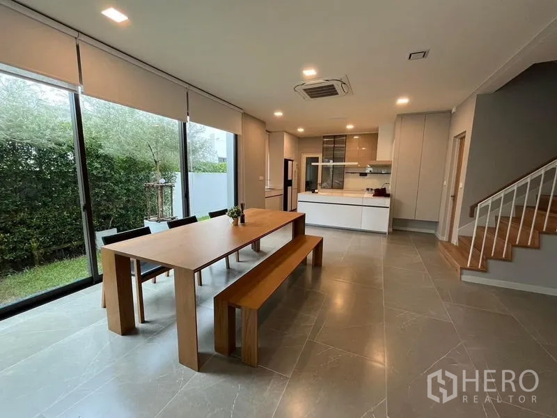 Detached House for rent or sale - Spacious dining-kitchen zone with tiled floors, ample lighting, and staircase to the upper level.