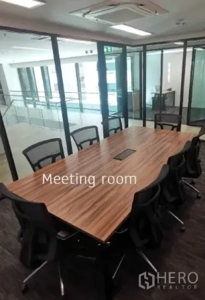 Office Space for rent in Khlong Toei, Bangkok - Glass-walled meeting room with long wooden conference table and ergonomic chairs in a modern office.