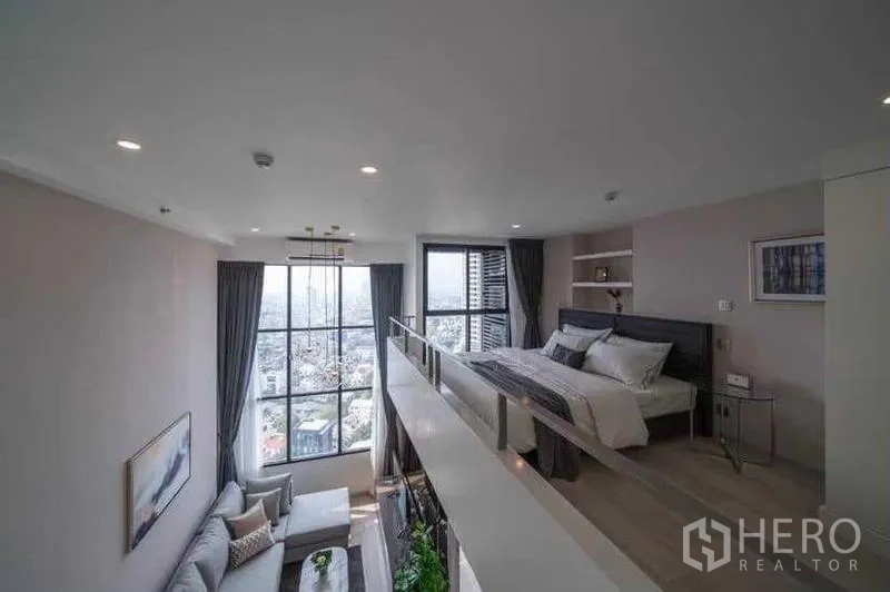 公寓 出租在Sathon, Bangkok - 夹层卧室，通过高窗欣赏城市景。