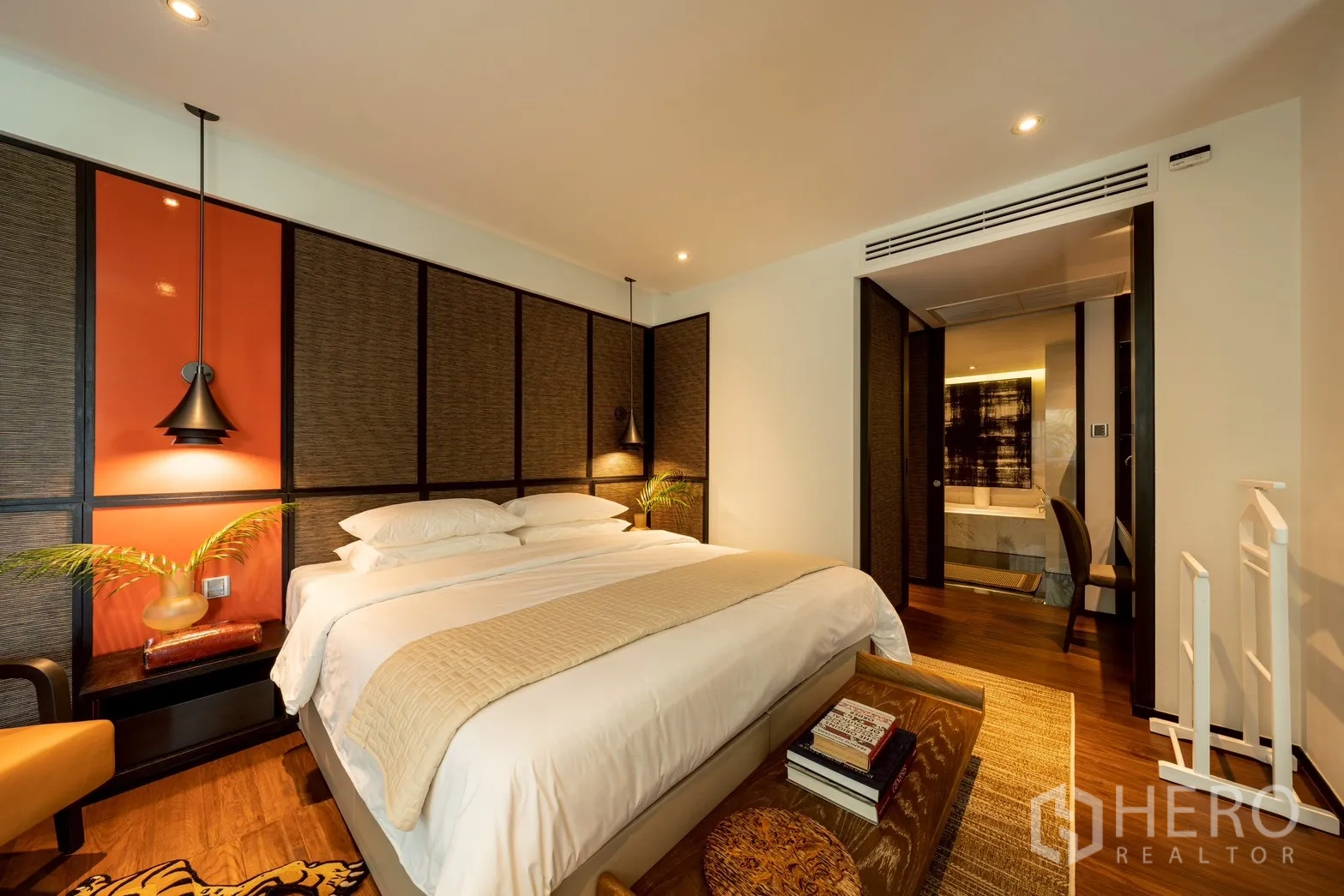คอนโด for rent or sale in Pathum Wan, Bangkok - มุมมองจากห้องนอนไปยังห้องน้ำในตัว แสงไฟอบอุ่นและพื้นไม้