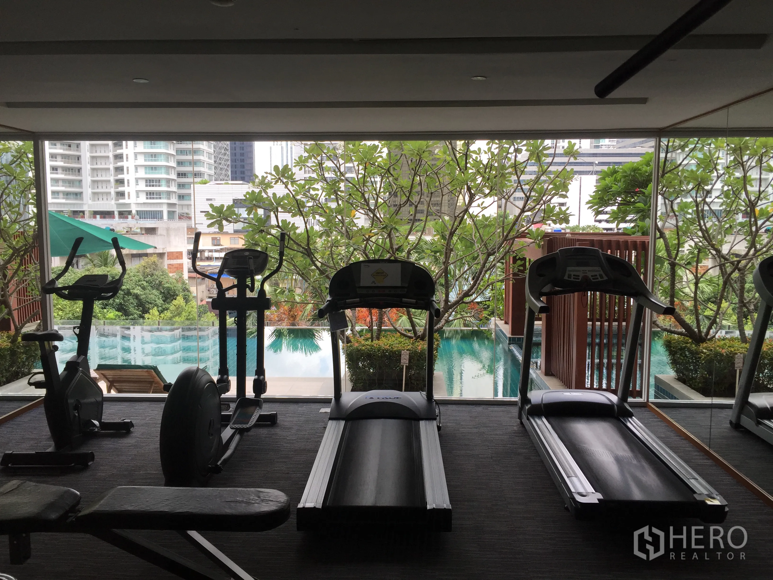 公寓 出租或出售在Watthana, Bangkok - 公寓健身房，跑步机与单车面向景观泳池与城市景观。