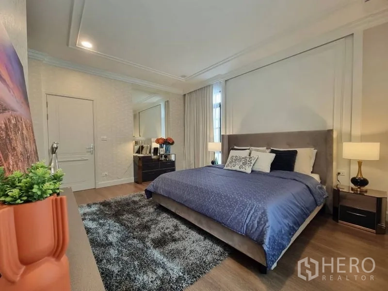 Detached House for rent in Saphan Sung, Bangkok - Elegant bedroom with upholstered bed, shaggy rug, and bedside lamps.