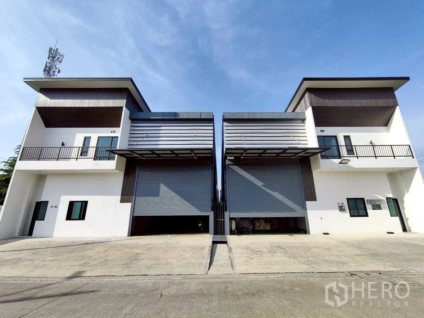 Warehouse for rent in Lam Luk Ka, Pathum Thani - Front view of industrial warehouse for rent with wide driveway and twin roller doors.