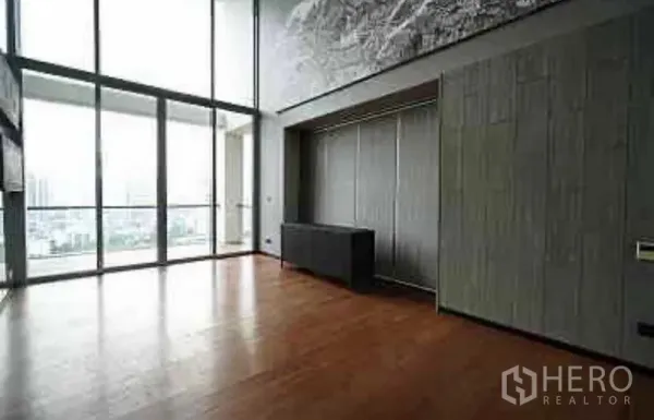 Condominium for rent in Sathon, Bangkok - Spacious living area with floor-to-ceiling glass, balcony and city views over warm timber floors.
