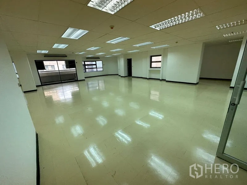 办公空间 出租在Pathum Wan, Bangkok - 明亮的大型开放式办公空间，浅色地板、白墙与成排荧光灯。