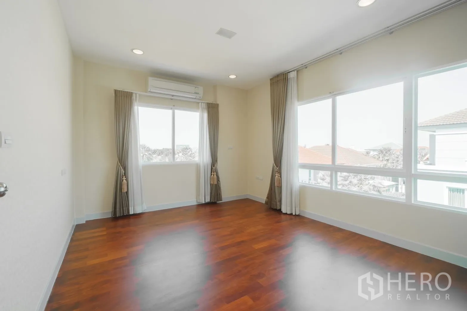 独栋房屋 for rent or sale in Saphan Sung, Bangkok - 明亮卧室，落地窗、窗帘与木地板。