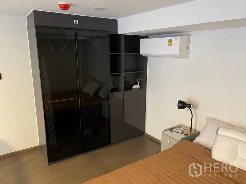 公寓 出租在Bang Rak, Bangkok - 夹层卧室内的黑色玻璃衣柜与空调。