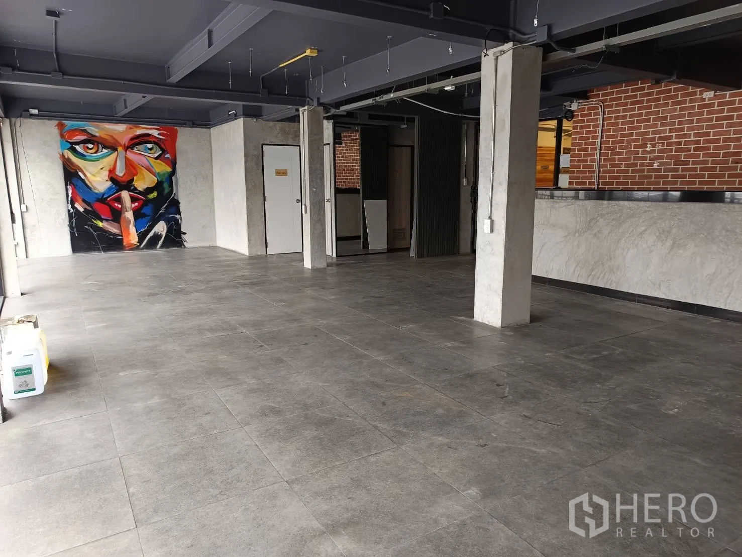 Retail Space for rent in Watthana, Bangkok - Large sales area with a colorful abstract wall mural, pillars and ample floor space.