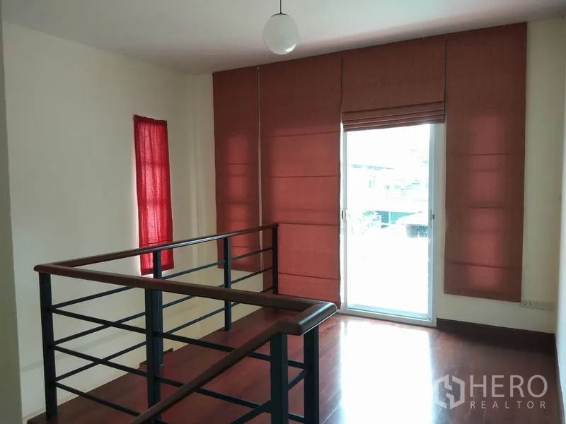 独立式住宅 出租在Watthana, Bangkok - 楼梯平台区，金属栏杆与玻璃门，红色窗帘