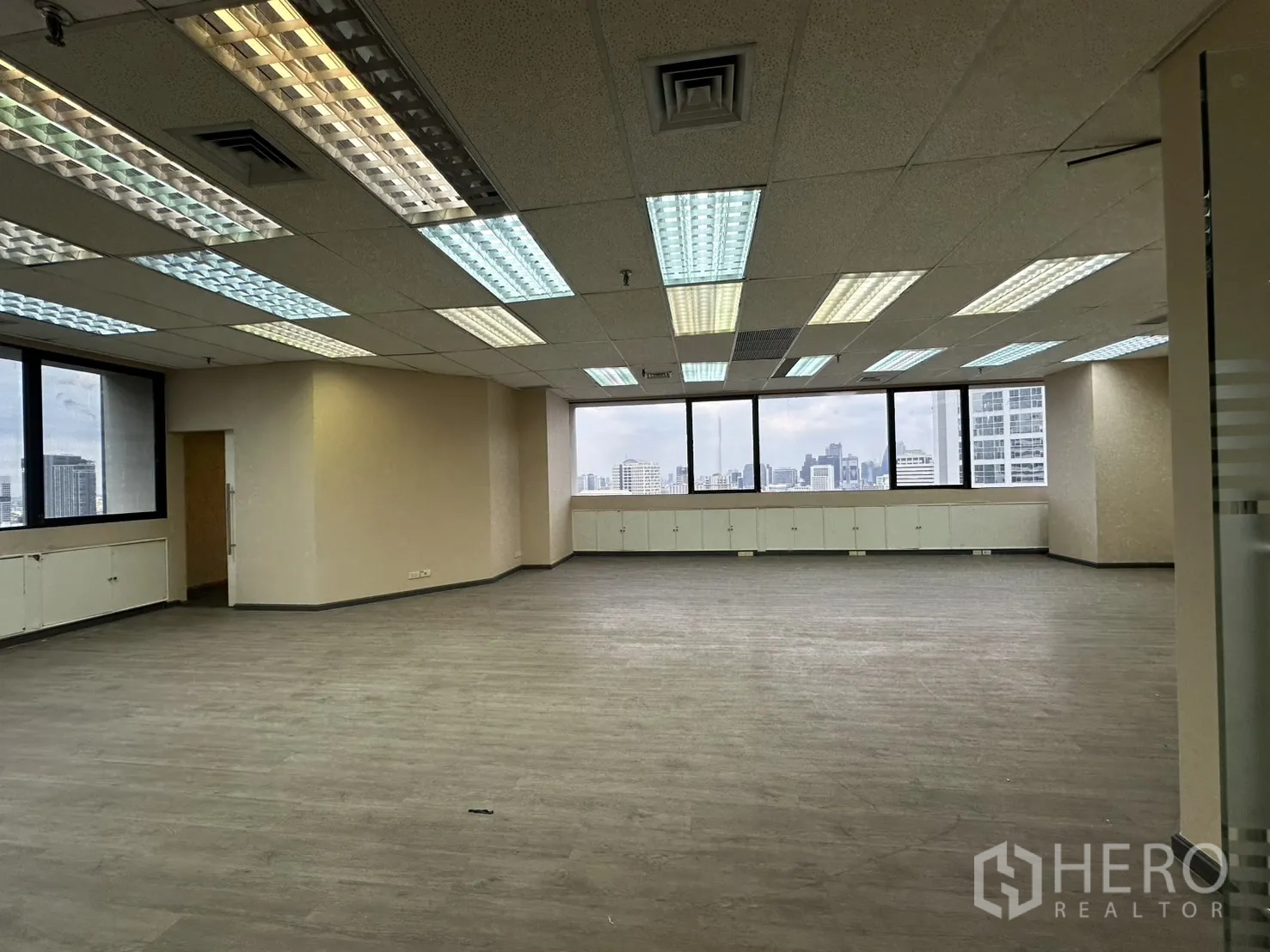 Office Space for rent in Bang Rak, Bangkok - Bright open workspace with panoramic windows, skyline view and built-in cabinets.