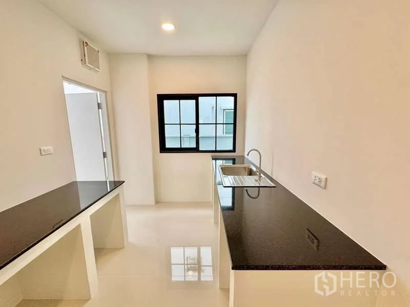 独立式住宅 出售在Bang Phli, Samut Prakan - 采光良好的独立厨房，黑色花岗岩台面与水槽