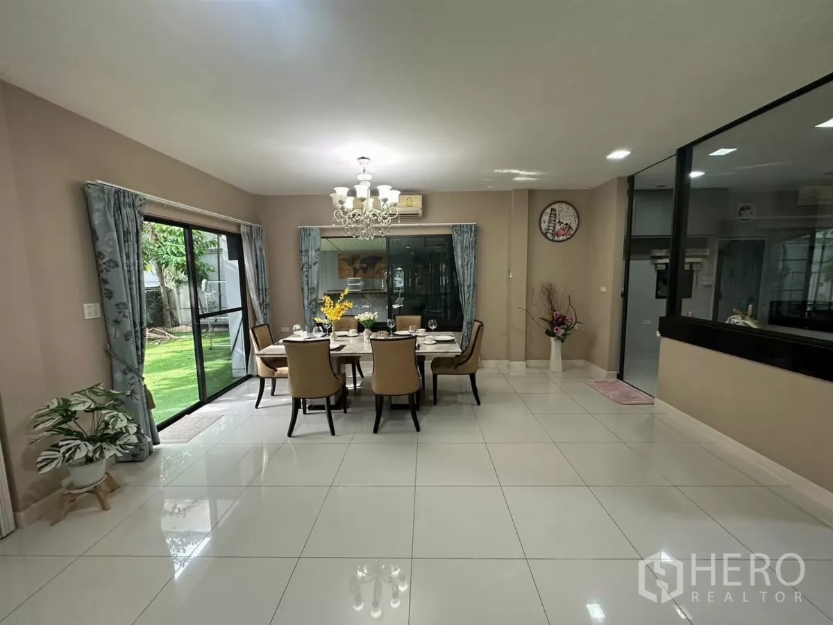 Detached House for rent or sale in Bang Kapi, Bangkok - Wide dining zone with marble table and sliding doors to the green yard.